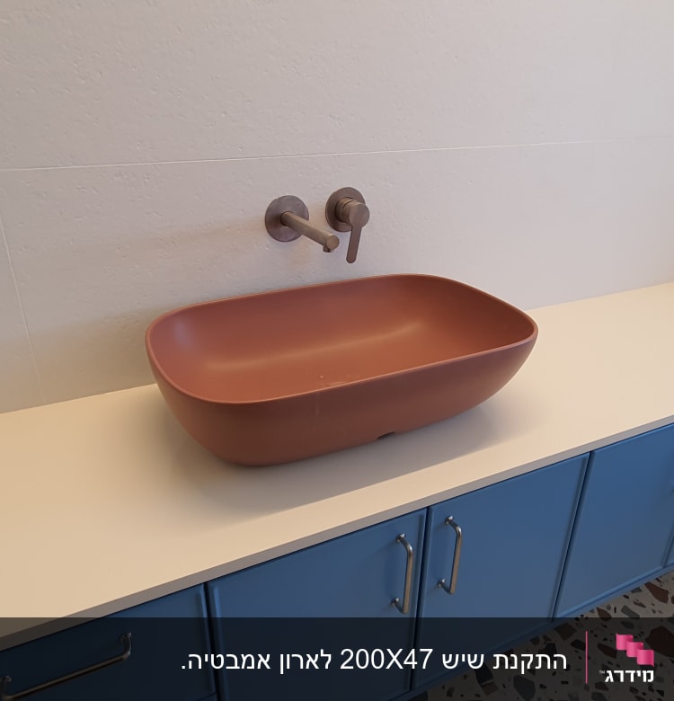 כיור חום על משטח שיש לבן בחדר אמבטיה